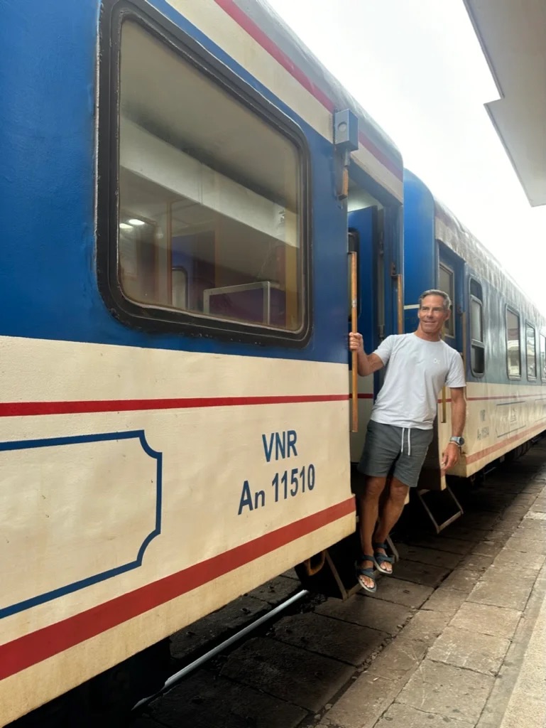 Shayne getting on a train in Vietnam