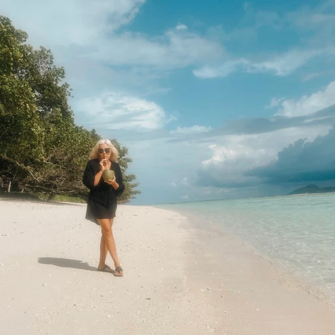 Enjoying a coconut on the beach in the seychelles